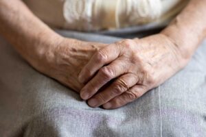 Resident discusses a written concern with an assisted living staff member at a quiet office table.